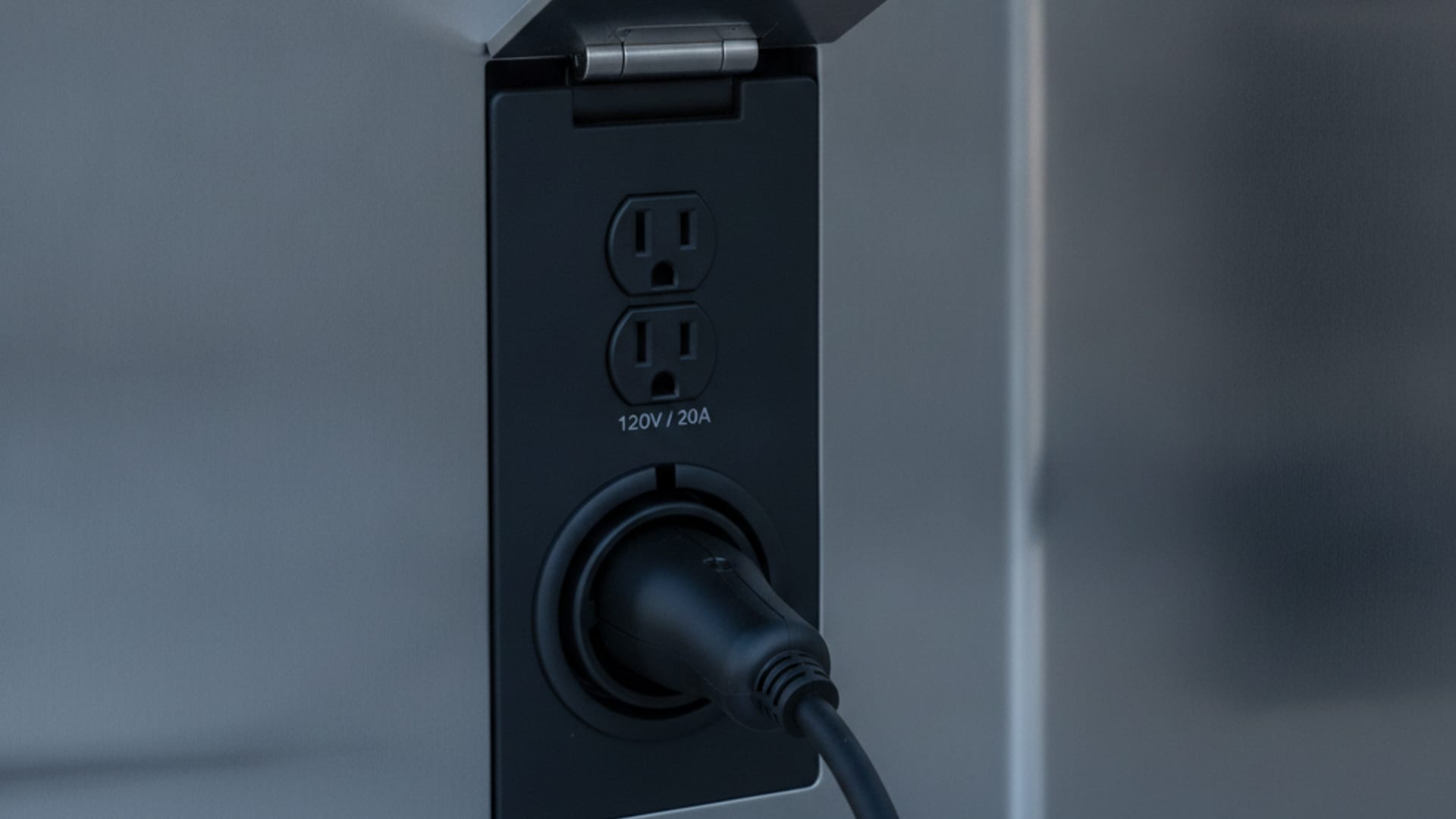 Charge Pro CHI rescue operator confirming charge progress beside a Tesla Model Y connected to a NACS charging cable on a Chicagoland street